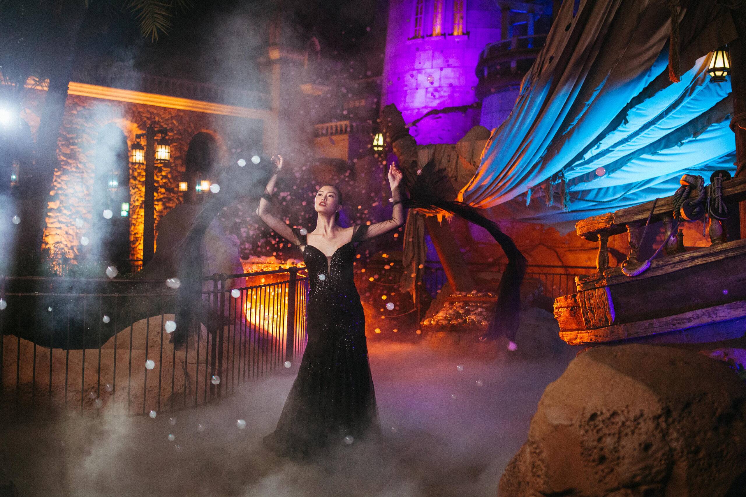 The new Disney’s Ursula wedding gown is shown in front of the Under the Sea – Journey of the Little Mermaid attraction in Magic Kingdom Park at Walt Disney World Resort in Lake Buena Vista, Fla. It is one of four new gowns inspired by Disney Villains and introduced as part of the 2024 Disney’s Fairy Tale Weddings collection from Allure Bridals. Inspired by the famous sea witch, the gown features a mermaid silhouette adorned with tonal sparkle beadwork on the bodice. It is available in ivory or black and features detachable sheer sleeves with ruffled detailing at the cuffs. (Claire Celeste, Photographer)