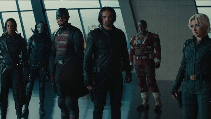 Members of the Thunderbolts* in a gray room with large windows behind them. From left to right: Ava Starr (Ghost), Antonia Dreykov (Taskmaster), John Walker (U.S. Agent), Bucky Barnes (Winter Soldier), Alexei Shostakov (Red Guardian), and Yelena Belova.